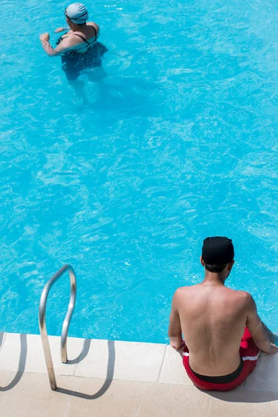 Man Wearing Red Shorts Sitting Edge Blue Pool Sunny Day — Stock Photo, Image