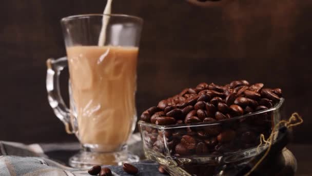 Wat Zwarte Koffiebonen Een Glazen Pot Naast Een Hand Melk — Stockvideo