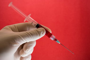 Kan bağışı konusu, doktor eli kanlı bir şırınga tutuyor.