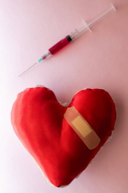 Büyük kırmızı bir kalpten şırıngayla kan alıyorum.
