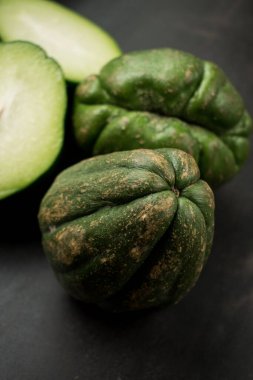 Siyah ahşap masada taze yeşil geleneksel Latin meyvesi.