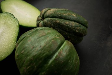 Siyah ahşap masada taze yeşil geleneksel Latin meyvesi.