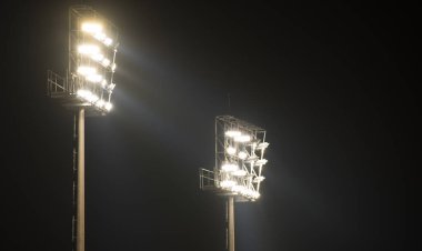 Karanlık bir gecede stadyumun ışığı açık.