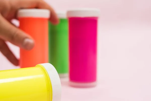  Neon boya, diğer neon boyalar ve pembe arka planda boya fırçaları.