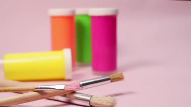 El fırçası ve pembe arka plandaki diğer neon boyaları alıyor.