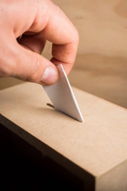 Hand casting vote in a wooden box