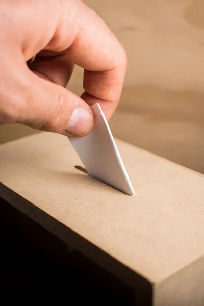 Hand casting vote in a wooden box