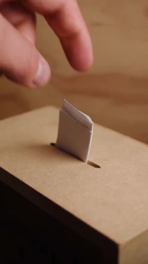 Hand casting vote in a wooden box