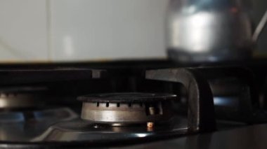 Hand lighting the stove withm an electric lighter