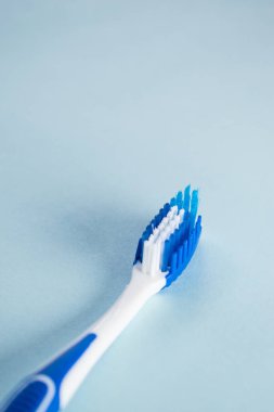 Blue toothbrush on a blue background with copy space