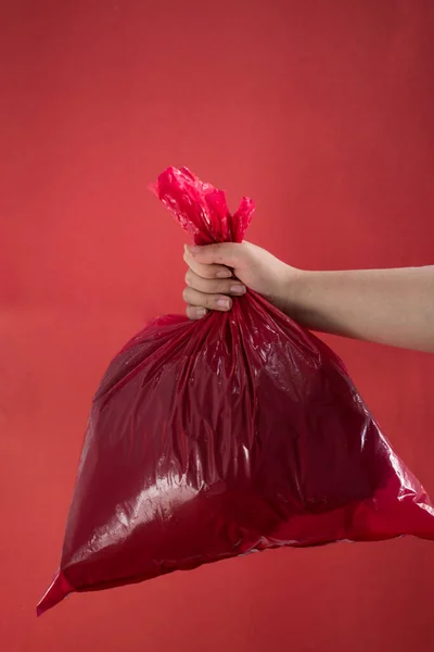 Hand Holding Red Plastic Bag Red Background — Stock fotografie