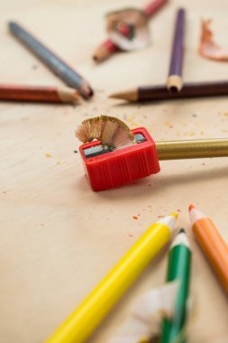 Ahşap bir masada renkli bir kalemi diğer renkli kalemlerle açmak.