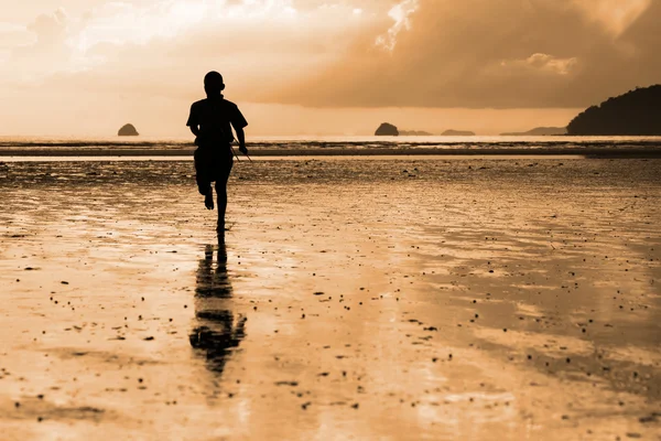 Lopende jongen op het strand Stockfoto