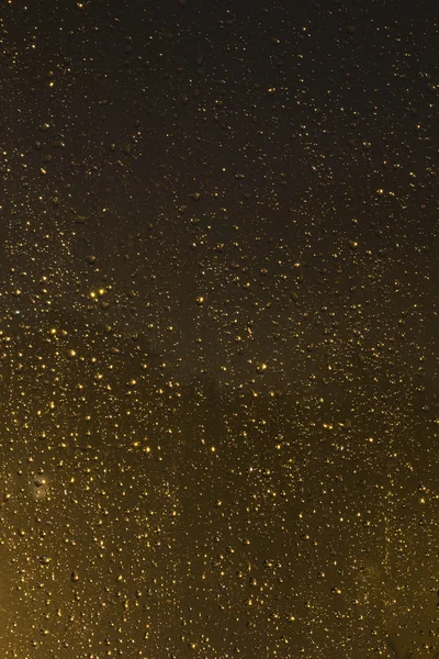 Regentropfen auf eine Fensterscheibe in der Nacht — Stockfoto