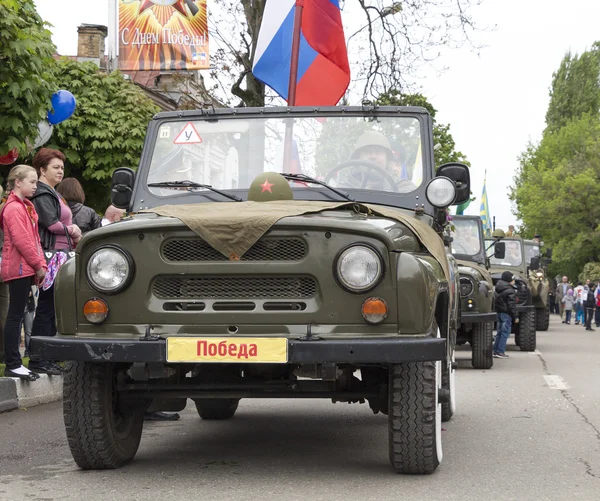 Kolom van militaire auto's met veteranen aan boord op parade ter ere — Stockfoto