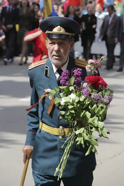 上の操作の花を持つ、勝利パレードのベテラン — ストック写真