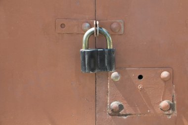 Kırmızı metal garaj kapısı üzerinde eski siyah asma kilit