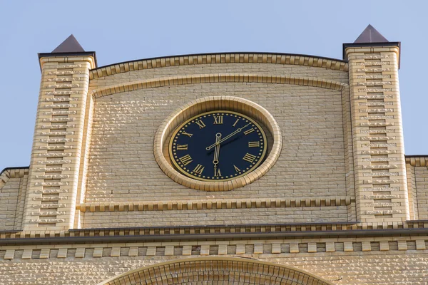 Clocks on the building of yellow brick — Stock Photo, Image