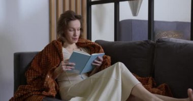 Genç bir kadın kendini geliştirmek için kitap okumakla meşgul.