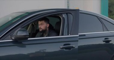 Genç, vahşi bir adam arabadan çıkar ve çerçeveden kaybolur.