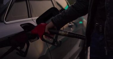 Gün batımında bir arabaya yakıt ikmali işleminin kapanışı