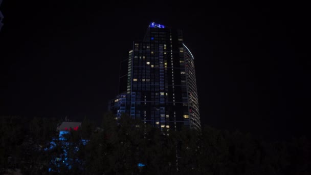Wieżowiec w nocy, co jest wyraźnie widoczne. Drogie wakacje kwarantanny. — Wideo stockowe