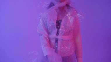 Güzel kız gelecek için moda gösteriyor. Polietilen giysileri..