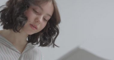 Kız yüzü yakın çekim. Temiz yüz hatları. Kız en sevdiği şeyle meşgul..