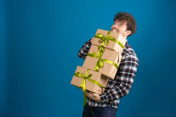 Mavi arka planda kameraya poz veren bir sürü yeteneği olan genç yakışıklı adam.