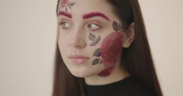 Zblízka-up mladé krásné dívky, jejíž tvář je krásně malované s květinami — Stock video