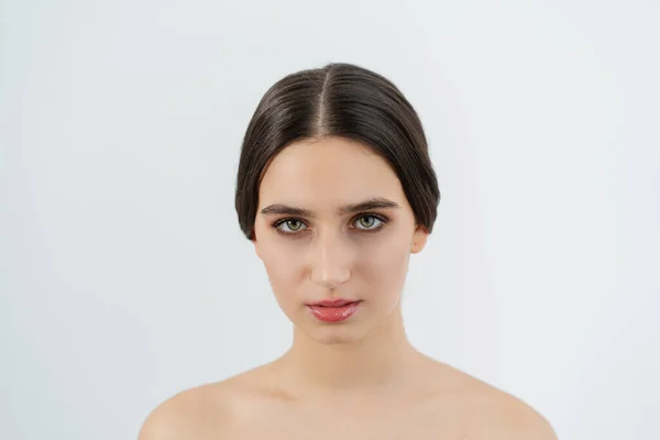 Fotografía horizontal de una chica de cerca. Belleza natural. Piel clara. Mira recta, pelo recogido en un bulto. — Foto de Stock