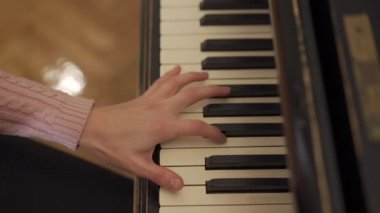 Piyano tuşlarını çeviren güçlü kadın ellerinin yakın çekimi