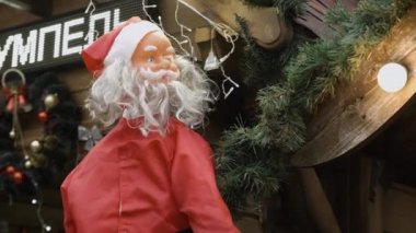 Chernivtsi, Ukrayna - 23.12.2019. Noel Baba 'nın ilginç plastik bebeği Noel ağacı dalları ve çelenkleri üzerinde parlıyor.