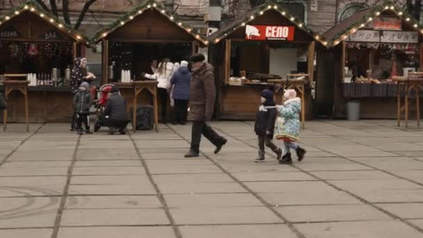 Chernivtsi, Ucrânia-23.12.2019. as pessoas descansam perto de casas de Ano Novo no coração da cidade — Vídeo de Stock