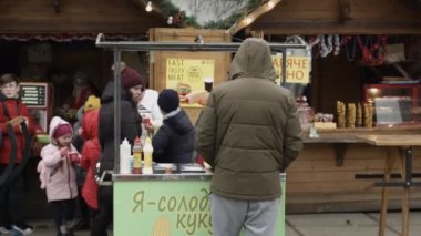 Chernivtsi, Ukrayna-23.12.2019. Genç adam yeni yıl fuarında emirlerini bekliyor.