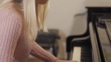 Piyanoya odaklanmış kırılgan bir kadının portresi.