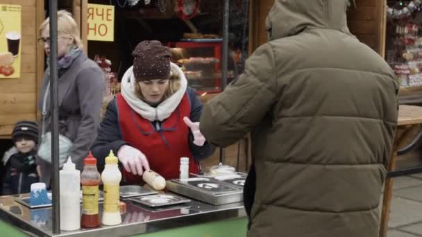 Tjernivtsi, Ukraina-23.12.2019. en ung kvinna lagar mat bakom disken och hennes man dricker sitt kaffe och går till vila — Stockvideo