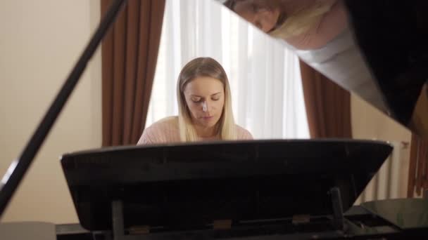 그 순간을 즐기고 있는 피아노에 집중하고 있는 한 매력적 인 소녀의 모습 — 비디오
