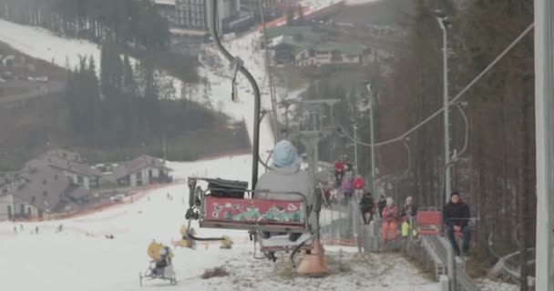 Bukovel, Ukraine - December 25, 2020: man on the lift at high altitude go down. Holidays in mountains — Stock Video