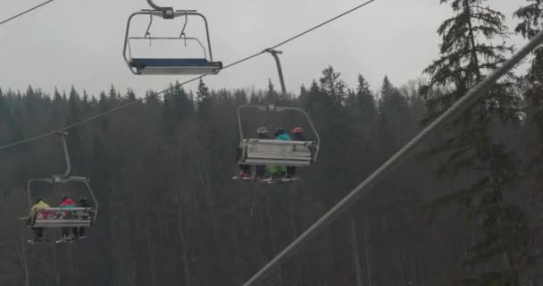 Bukovel, Ucrania - 25 de diciembre de 2020: El ascensor a gran altitud eleva a los turistas a la montaña. la gente va a esquiar en la temporada de invierno. — Vídeo de stock