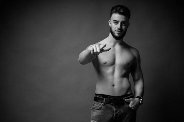 Foto en blanco y negro de un tipo con barba y cabello oscuro mostrando un dedo recto. — Foto de Stock