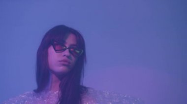 Gözlüklü ve polietilen giyen genç kız. Doğa plastiğe karşı.