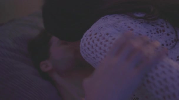 Närbild av en ung man som är passionerat kysst av en flicka och börjar klä av förföriskt — Stockvideo