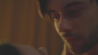 Hayranlıkla bakan adam sevgilisine bakar ve durmadan onu öper.