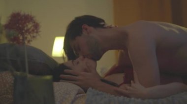 Yatakta genç bir çifti öpmek ve bir tutku anında gebeliği ihmal etmek.