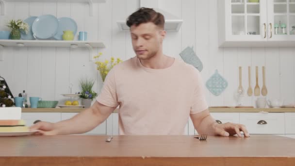 Ein an einem Tisch sitzender Freak hält einen Teller mit Waschlappen hoch — Stockvideo