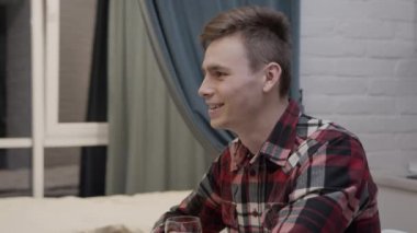 Genç bir adam geceyi sevgilisiyle bir bardak köpüklü şarap içerek geçirmekten hoşlanır.