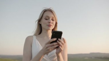 Chernivtsi Ukrayna - 22 05 2020. Mutlu kız akıllı telefonuna bir şeyler yazıyor. 4k video