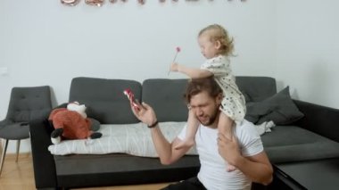 Çocuk babasının boynuna oturur ve bir balona yumruk atar. Eğlence odası karantinaya alındı..