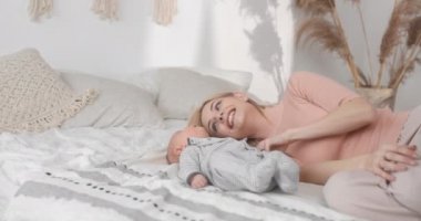 Annem bebekle birlikte yatakta yatıyor. Aile tatili yatak odasında..